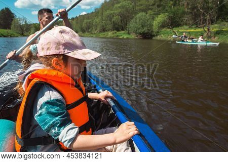 Family Kayak Trip. Father And Daughter, And Elderly Couple Senior And Seniora Rowing Boat On The Riv