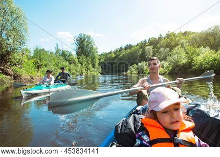 Family Kayak Trip. Father And Daughter, And Elderly Couple Senior And Seniora Rowing Boat On The Riv