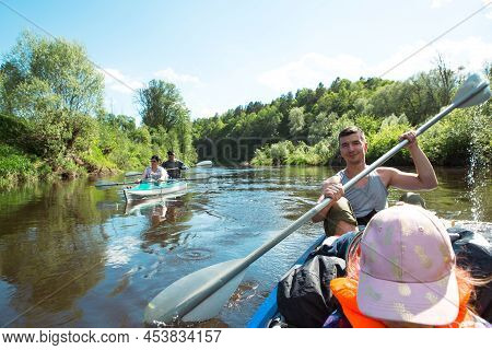 Family Kayak Trip. Father And Daughter, And Elderly Couple Senior And Seniora Rowing Boat On The Riv