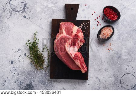 Raw Beef Meat. Rough Piece Of Meat On Bone For Roast Or Soup With Salt, Pepper, Thyme And Rosemary O