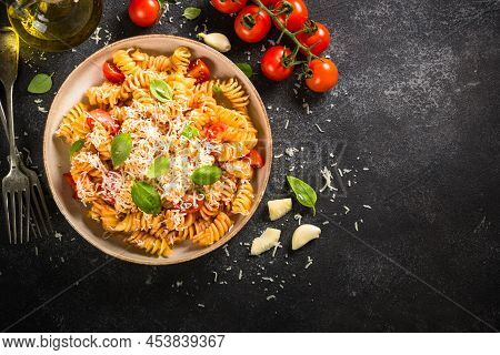 Italian Pasta Alla Arrabiata With Fresh Tomatoes, Basil And Parmesan On Black Stone Table. Flat Lay 