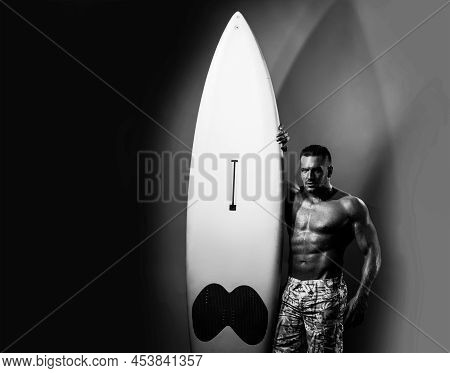 Sexy Man With Serf Board. Male Serfer With Fit And Firm Body. Neon Surfboard Light Background.