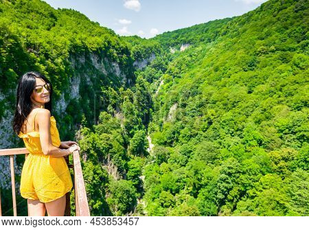 Young Attractive Caucasian Woman Stands In A Scenic Viewpoint Of Okatse Canyon With Blooming Green S