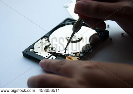 The Abstract Image Of Inside Of Hard Disk Drive With Technician Fixing Using Screw Driver On White B