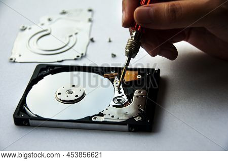 The Abstract Image Of Inside Of Hard Disk Drive With Technician Fixing Using Screw Driver On White B