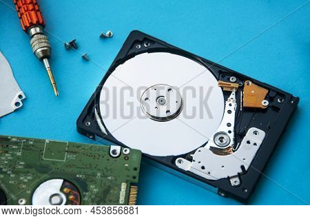 The Abstract Image Of Inside Of Hard Disk Drive On Blue Cover And Screw Driver Background. Concept O