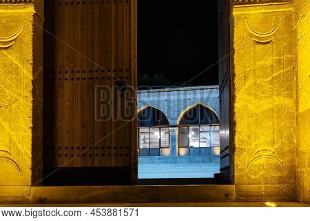 Open Wooden Gates Show Entrance To Courtyard Of Alaeddin Mosque In Nighttime. Konya, Turkey.
