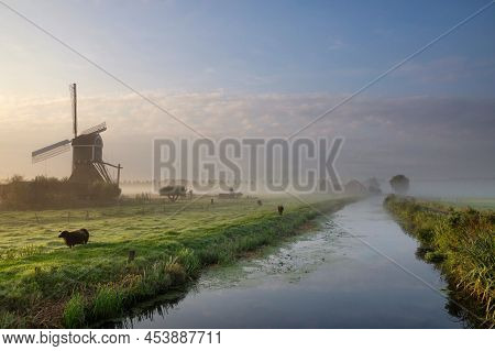 Windmill The Wingerdse Molen Near The Dutch Village Bleskensgraaf Along A Canal On A Misty Morning