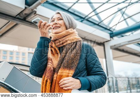 Senior Woman Send Message With A Mobile Phone In A Stransport Station