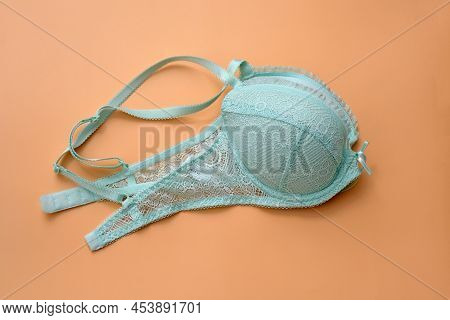 Green Bra With Lace On A Beige Background. Bra Pale Blue With Pushap Folded In Two. Beautiful Linger