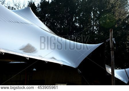White Tarpaulin Taut, Shading From The Sun And Rain Over The Terrace Of The Restaurant, On The Playg
