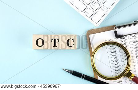 Otc Word On A Wooden Cubes On Blue Background With Chart And Keyboard