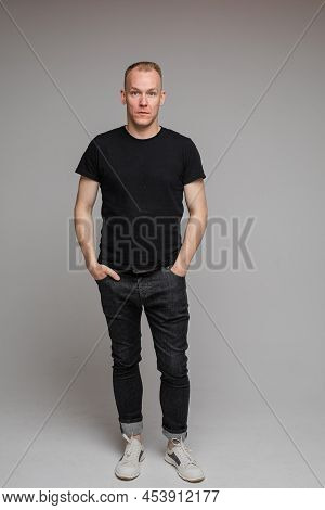 Full Lenth Caucasian Man With Short Fair Hair Keeping Hands In The Pockets