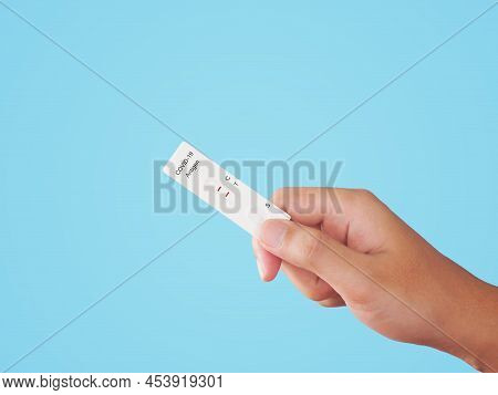 Human Hand Holding Empty Atk Or Antigent Test Kit For Covid-19 Over Blue Background.