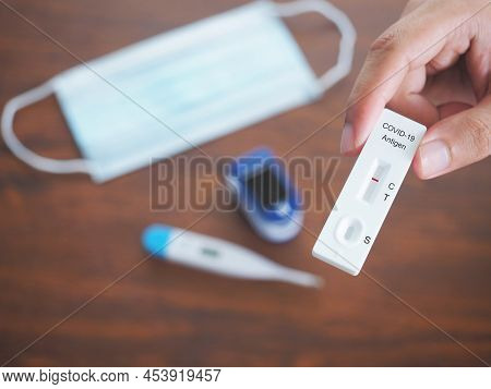 Human Hand  Holding Atk Or Antigent Test Kit Showing  Positive And Set Of Self Test For Protection C