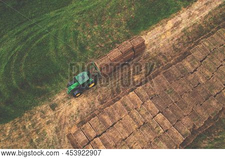 John Deere Tractor With Straw Hay Trailer The Transporting Round Bales. Storage Hay At Farm. Hay For