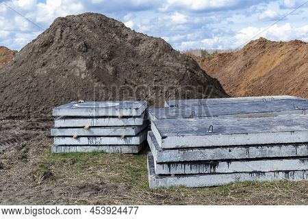 Reinforced Concrete Slabs At A Construction Site Against A Blue Cloudy Sky And Earth. Folded Plates 