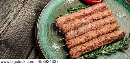 Raw Lula Kebab On Skewers With Spices On A Cutting Board Light Background. Lula Kebab, Traditional C