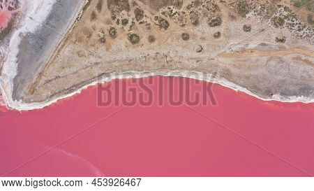 Flying Over A Pink Salt Lake. Salt Production Facilities Saline Evaporation Pond Fields In The Salty