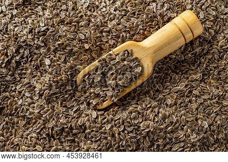 Whole Dill Seeds In A Wooden Scoop Against Seed Background Close-up. Organic Fruits Of Anethum Grave