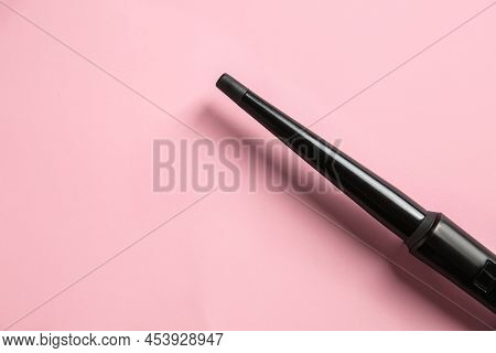 Modern Clipless Curling Hair Iron On Pink Background, Top View. Space For Text