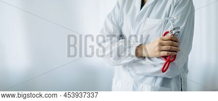 A Doctor Standing With His Arms Crossed Holding A Stethoscope, A Doctor From The Hospital. Medical S