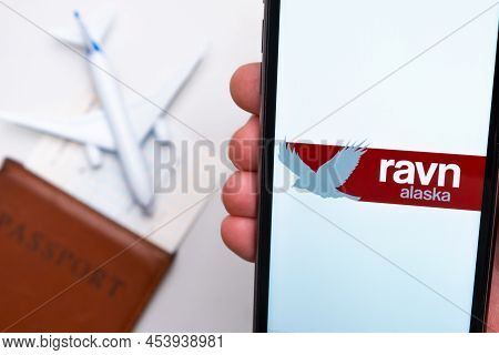 Ravn Alaska Airline Logo On The Mobile Phone Screen With A Plane, Passport And Boarding Pass On The 