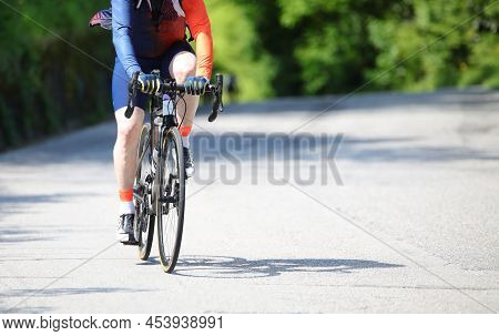Cyclist With Sportswear And Shorts On A Racing Bike Pedaling On The Asphalt Road During The Cycling 