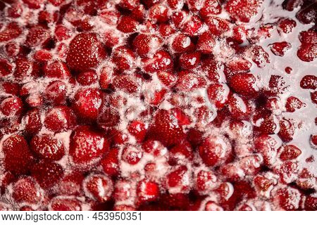 Process Of Making Homemade Raspberry Jam. Red Sweet Syrup Boiling On The Stove Closeup. Strawberry J