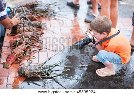 Ładny chłopczyk fotografowanie na targ z owocami morza