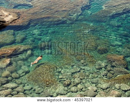 Gente de buceo en una cuenca Natural en la costa de rocas de Lanzarote
