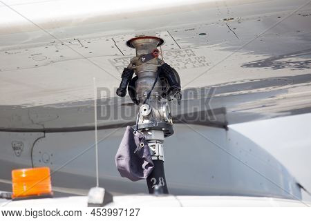 Refueling Of A Passenger Plane. The Tanker Fills The Tanks In The Wing.