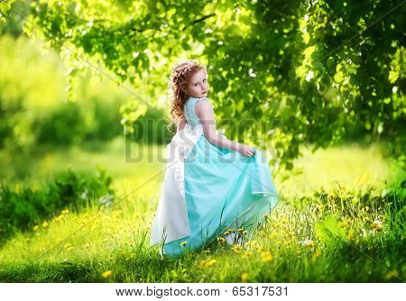 Beautiful Little Girl In A Blue Dress With A Large White Bow In Spring Garden. Little Princess.