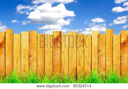 wooden fence with green grass and field on background 