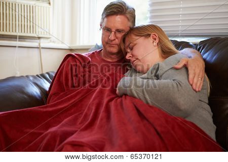 Couple Trying To Keep Warm Under Blanket At Home