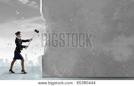 Young attractive businesswoman with hammer in hands
