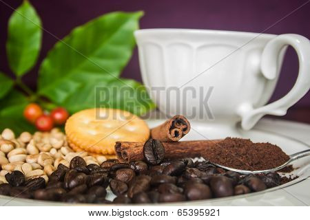 Coffee cup, beans, cinnamon and cracker