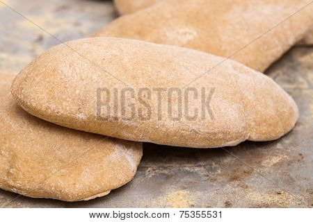 Loaves of traditional Egyptian homemade brown pita bread, fresh from the oven, called aish baladi