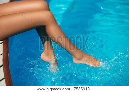 Close-up of slim woman legs in swimming pool
