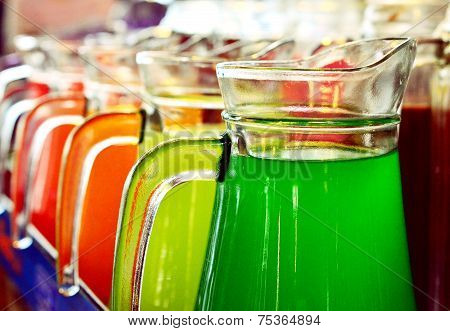 A Row Of Colorful  Juices Served in Jug