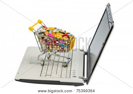 tablets with shopping cart and computer. symbol photo for the purchase of medicines on the internet