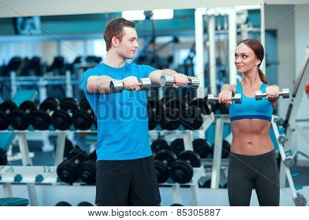 Beautiful girl in sports club with instructor