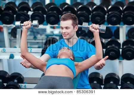 Beautiful girl in sports club with instructor