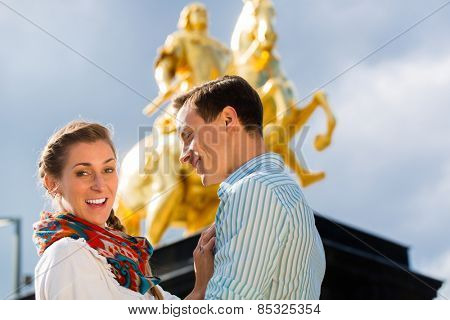 Tourist couple in Dresden in front of Goldener Reiter statue