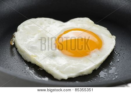 Heart made of fried egg on teflon pan.  