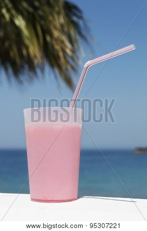 Pink Beverage In Plastic Cup Against Blue Sea And Sky