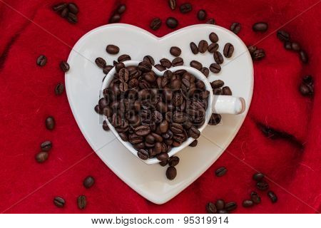 Heart Shaped Cup With Coffee Beans On Red