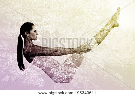Toned woman doing the boat pose in fitness studio against beautiful pink leaved trees