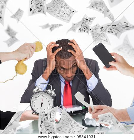 hand holding phone against frustrated afro businessman with head in hands at desk