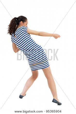 back view of standing woman pulling a rope from the top or cling to something.  Rear view people collection. African-American woman in a striped dress in barely pulling a rope on the right.